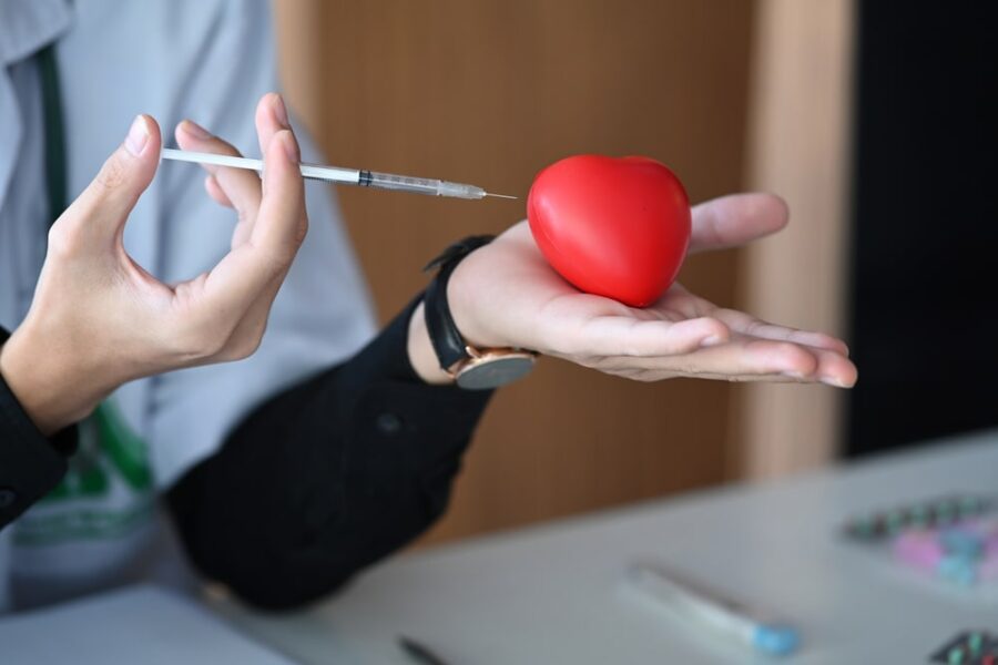 doctor holding red heart and syringe