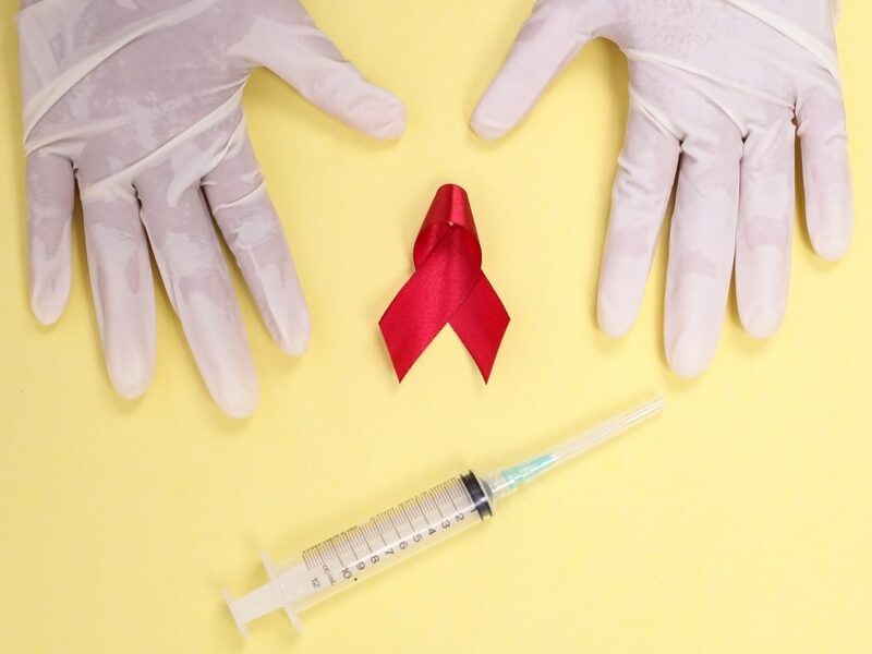 Red Ribbon with Medical Gloves and Syringe