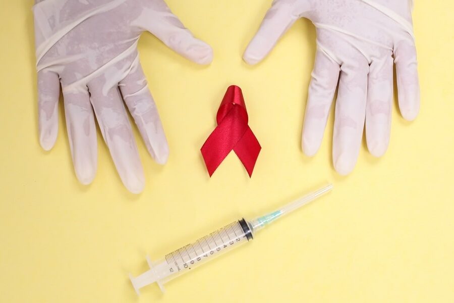 Red Ribbon with Medical Gloves and Syringe