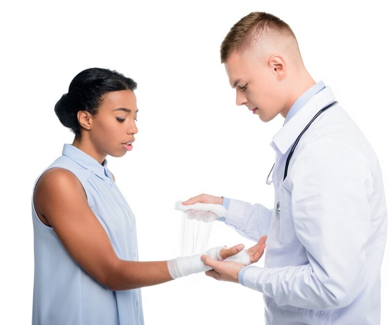 doctor puting bandage on womans hand