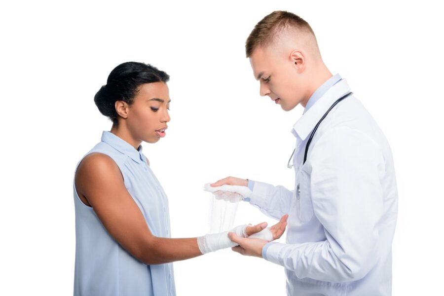 doctor puting bandage on womans hand